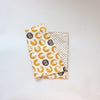 A rolled soft cotton baby pillow cover featuring a pattern of yellow and white elephants on a cream background.
