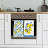 A set of two blue-edged lemon kitchen towels hanging in a built-in oven cabinet.