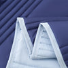 A close-up of a light blue quilted blanket folded on a dark purple surface.