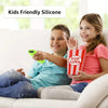 Two children are shown using glow-in-the-dark silicone remote covers while sitting on a couch.
