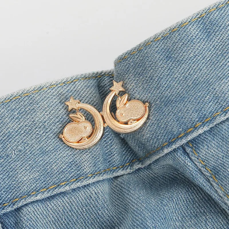 Gold crescent moon and rabbit button clips attached to a denim fabric