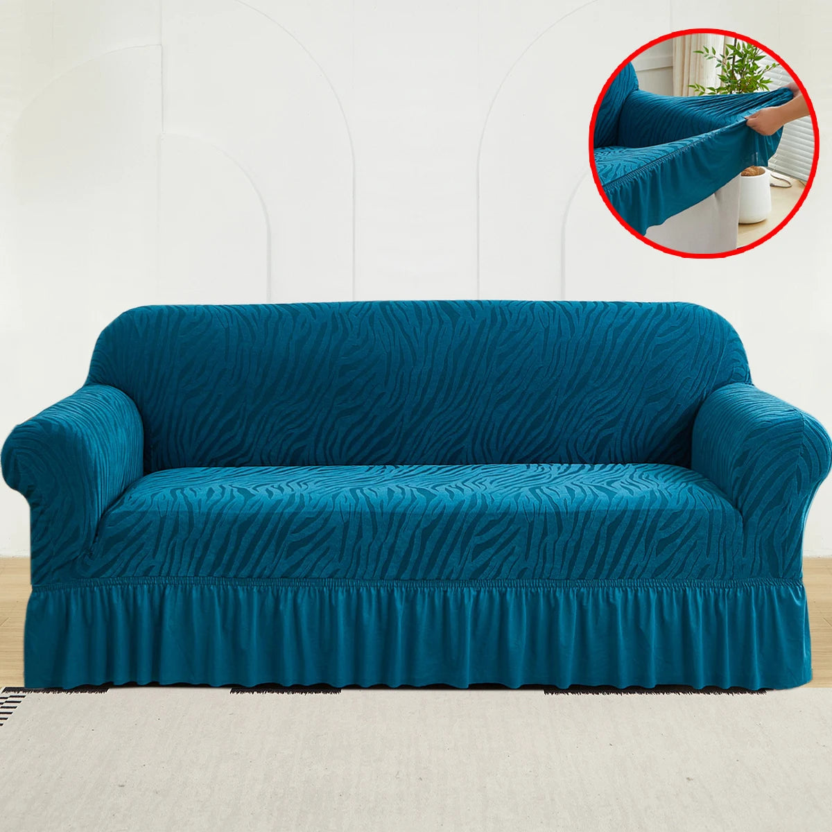 A teal anti-slip jacquard sofa slipcover featuring a textured pattern and gathered front panel.