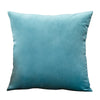A square velvet throw pillow cover in a muted teal color.