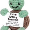 A handmade plush turtle-shaped pocket doll in green and brown.