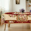 An elegant floral tablecloth featuring vintage rose prints on a deep red background, displayed on a wooden table.