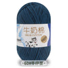 A skein of dark blue milk cotton yarn with a label featuring Chinese text and a stretch icon.