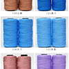 A collection of hand knitting and crochet cord spools in various shades of pink, blue, and purple.