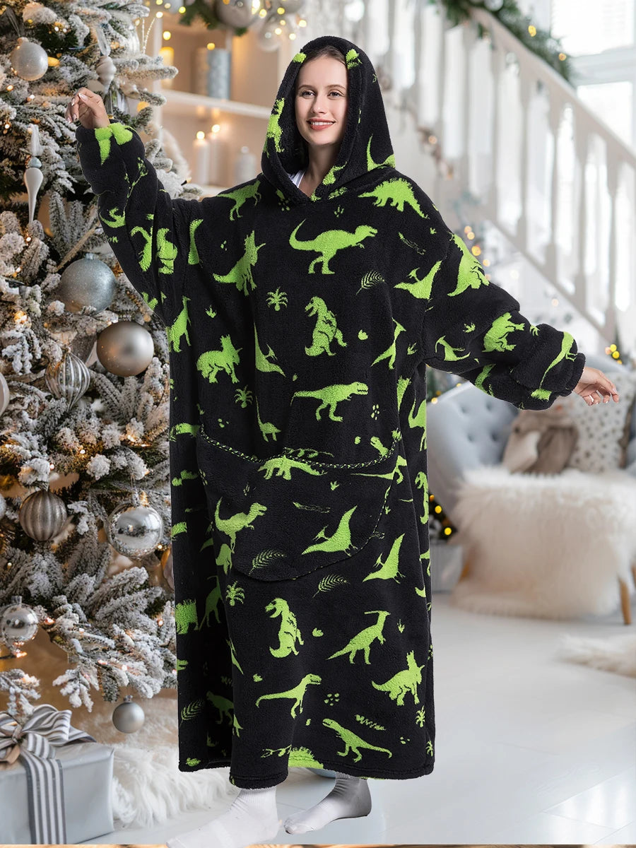 A woman wearing a black and lime green dinosaur print sherpa fleece oversized hoodie in a bright interior setting.