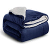 A dark blue sherpa fleece blanket folded and rolled, showing a white fluffy trim.