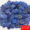 A pile of assorted dark blue resin sewing buttons for crafting and DIY projects.