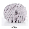 A ball of light gray hand-woven chunky chenille yarn.