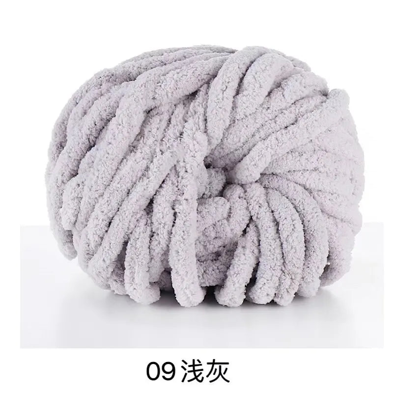 A ball of light gray hand-woven chunky chenille yarn.
