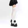 A pair of black ruffled fabric and white suspender socks worn by a person.