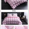 Pink luxury goose down duvet blanket displayed on a bed in a modern bedroom setting.