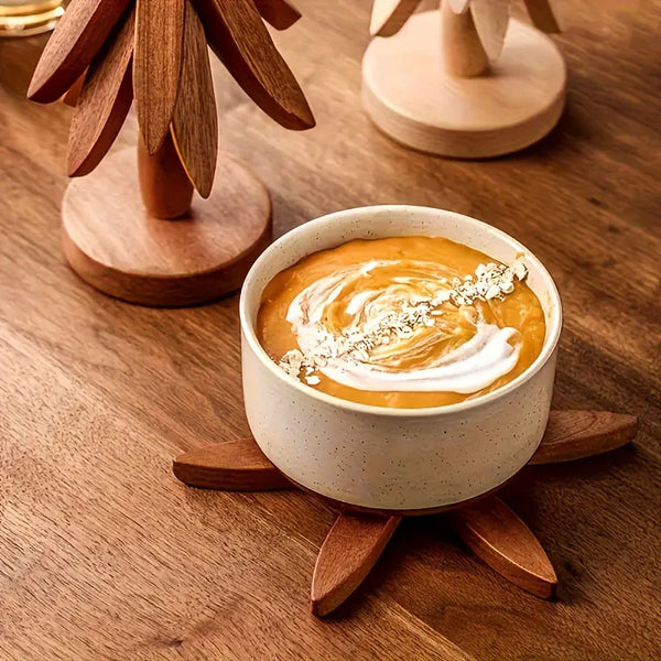 A ceramic bowl filled with orange-colored soup or puree is placed on a wooden placemat.