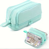 A mint green fabric pencil pouch with a zipper and decorative accents, shown next to its open interior.