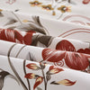 Close-up of a floral print fabric featuring red and brown leaves on a white background.