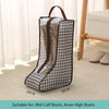 A portable boot storage bag with a carry handle, featuring a black and gray houndstooth pattern, shown on a light carpet.