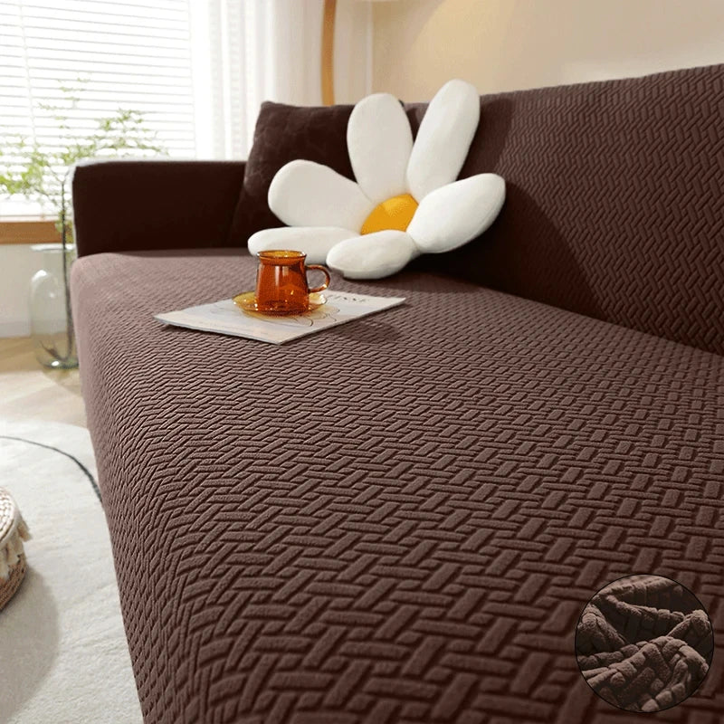 A dark brown textured sofa cover featuring a quilted pattern and a white floral cushion on a living room sofa.