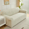 A beige sofa slipcover featuring a jacquard leaves pattern in light beige and white stripes.