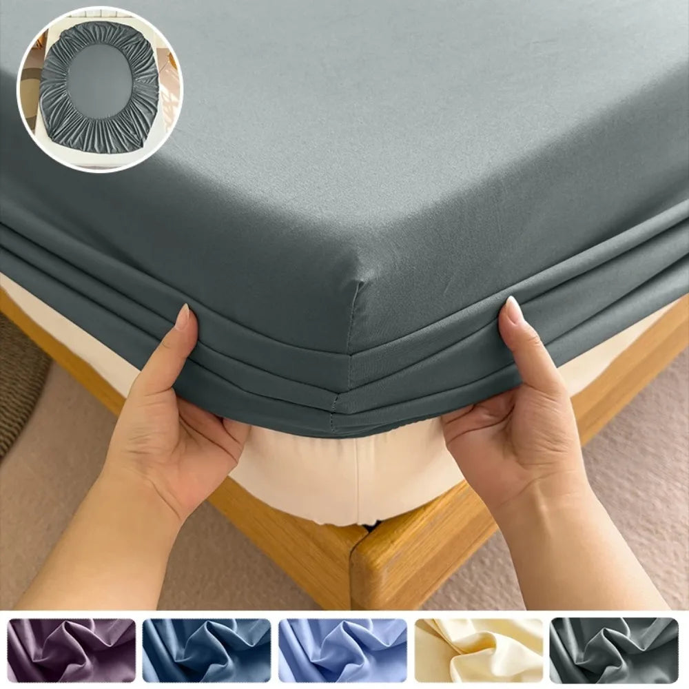 Hands folding a gray fitted bed sheet set with various fabric colors