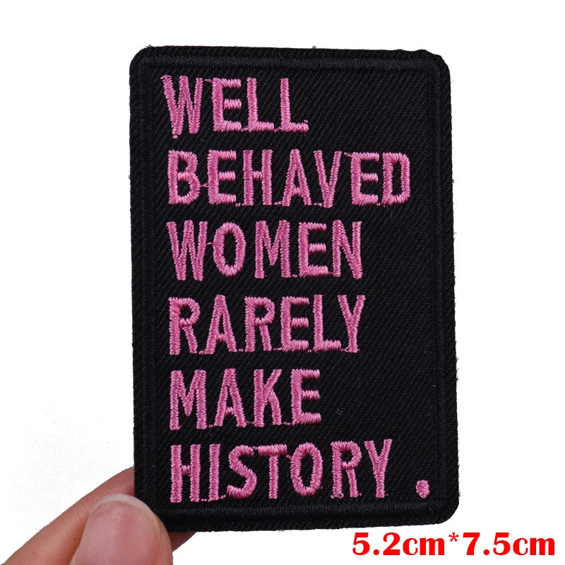 Black embroidered patch with pink text that reads Well Behaved Women Rarely Make History