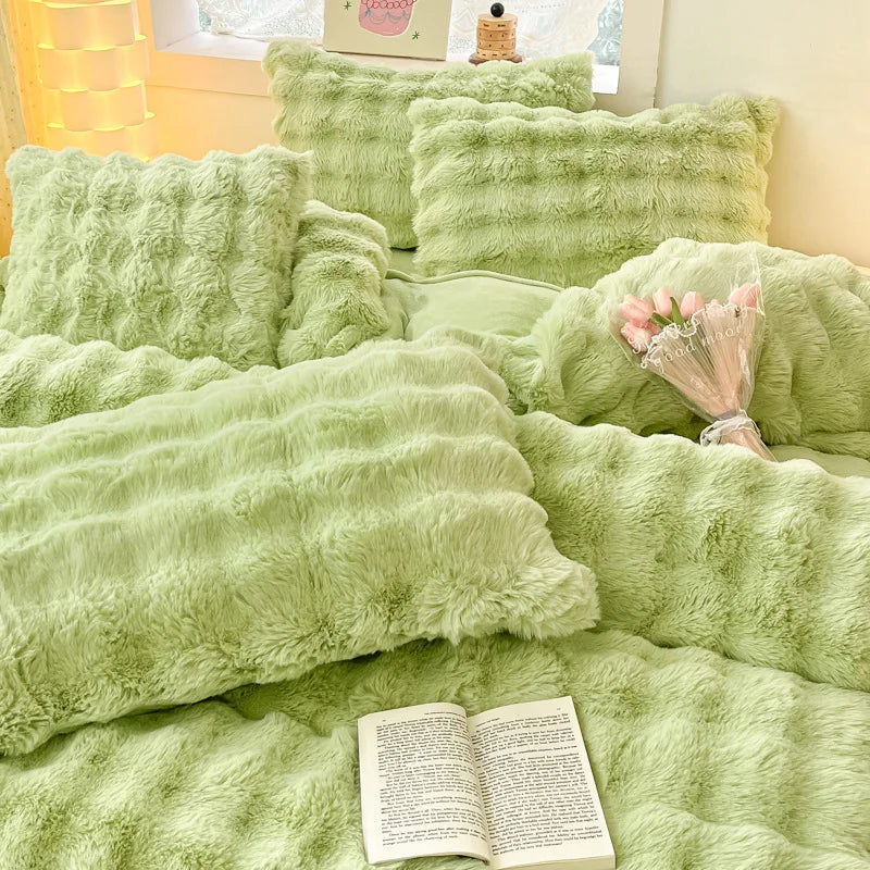 A pile of soft, light green plush rabbit hair bedding and pillows.