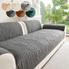 A gray anti-slip sofa cushion with a textured pattern is displayed on a light-colored sofa.