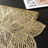 Gold-colored, intricately cut lace or perforated material used as a decorative element.