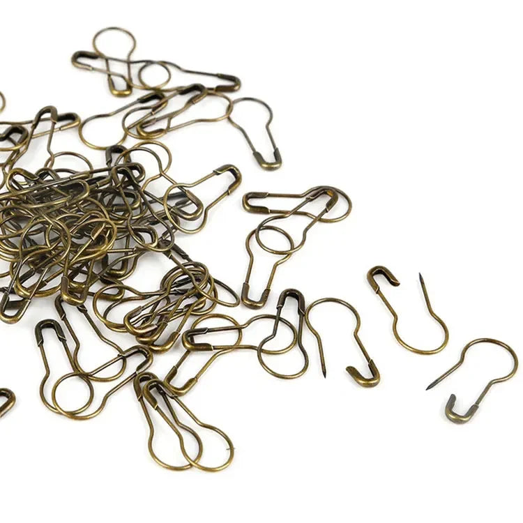 A pile of brass colored safety bulb pins for knitting and sewing.