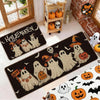 A set of Halloween ghost and pumpkin print non-slip kitchen rugs displayed on a floor.