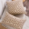 A beige chenille jacquard throw pillowcase with a diamond pattern resting on a white textured surface.