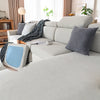 A light gray plush elastic sofa cushion cover with dark patterned fabric and a blue accent cushion.