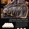 A luxurious gray ice silk summer blanket set is displayed on a bed with a woman relaxing under the fabric.