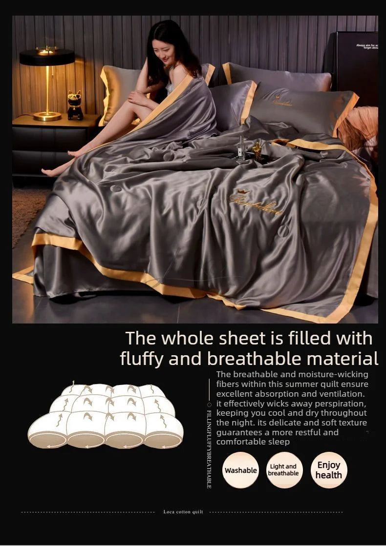 A luxurious gray ice silk summer blanket set is displayed on a bed with a woman relaxing under the fabric.