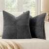 A set of four gray neutral corduroy throw pillow covers with a vertical ribbed texture and patchwork design on a light sofa.