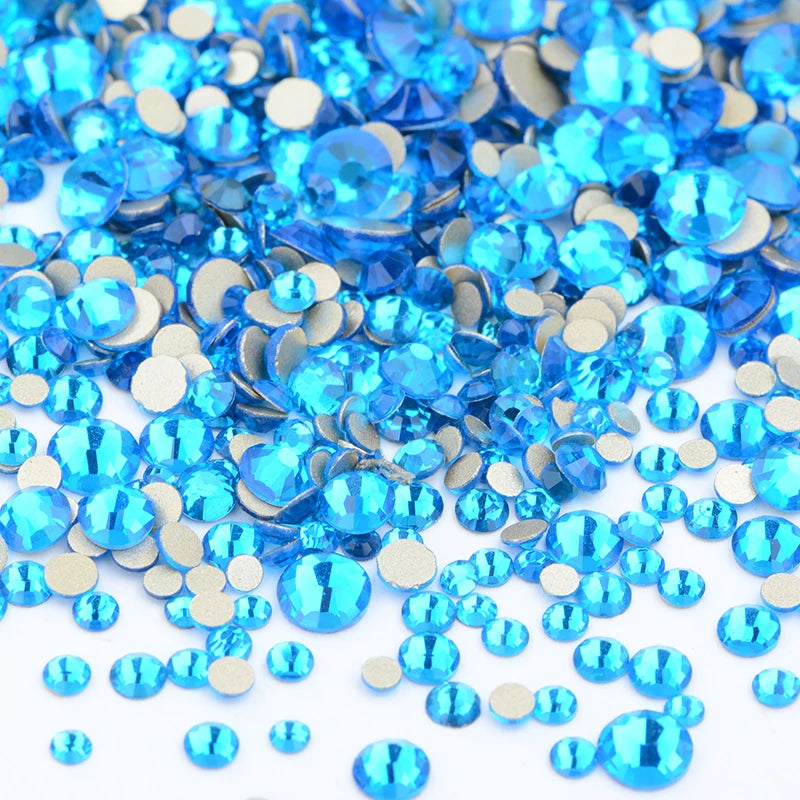 A pile of assorted blue and clear glass rhinestones for DIY crafts