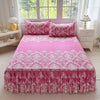 Pink floral print bed skirt set with a pink floral print bedspread on a white bed.