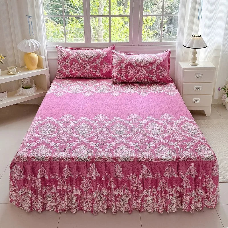Pink floral print bed skirt set with a pink floral print bedspread on a white bed.