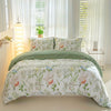 A leaf floral duvet cover set featuring white background with green and red botanical patterns on a bed.