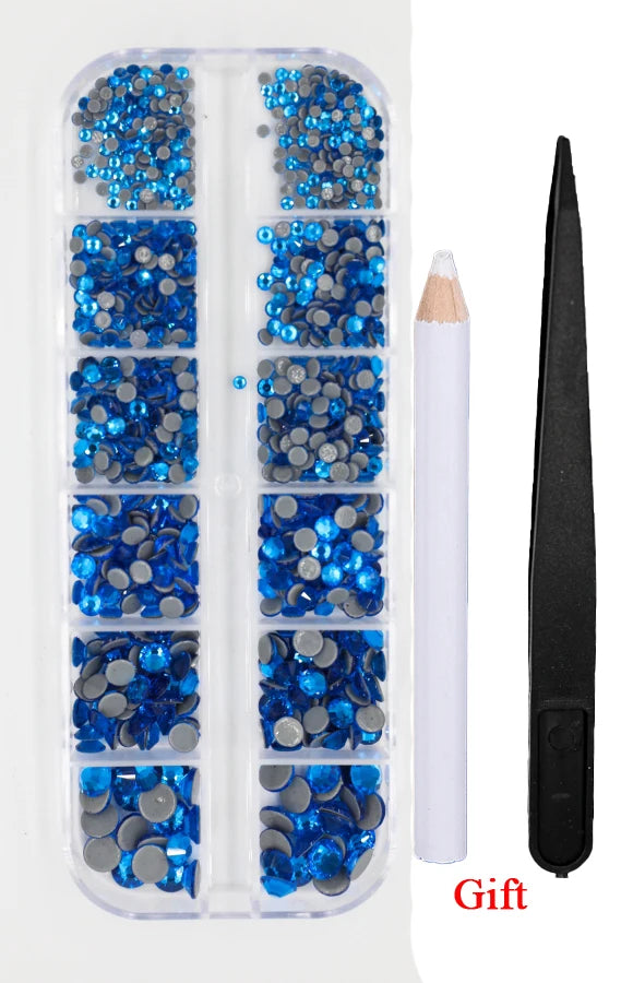 A clear plastic container holds various blue and silver crystal hot fix rhinestones and an applicator tool.