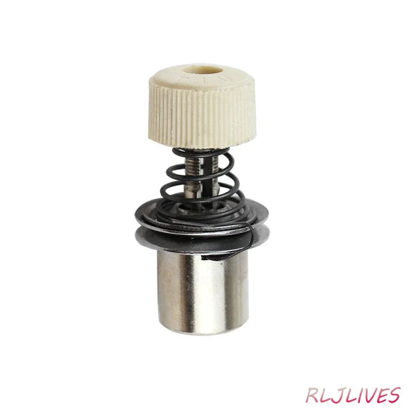 A silver sewing machine gripper with a ribbed plastic top and a coiled spring mechanism.