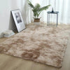 A thick, fluffy brown silk wool area rug placed on a light wood floor next to a potted plant and a small table.