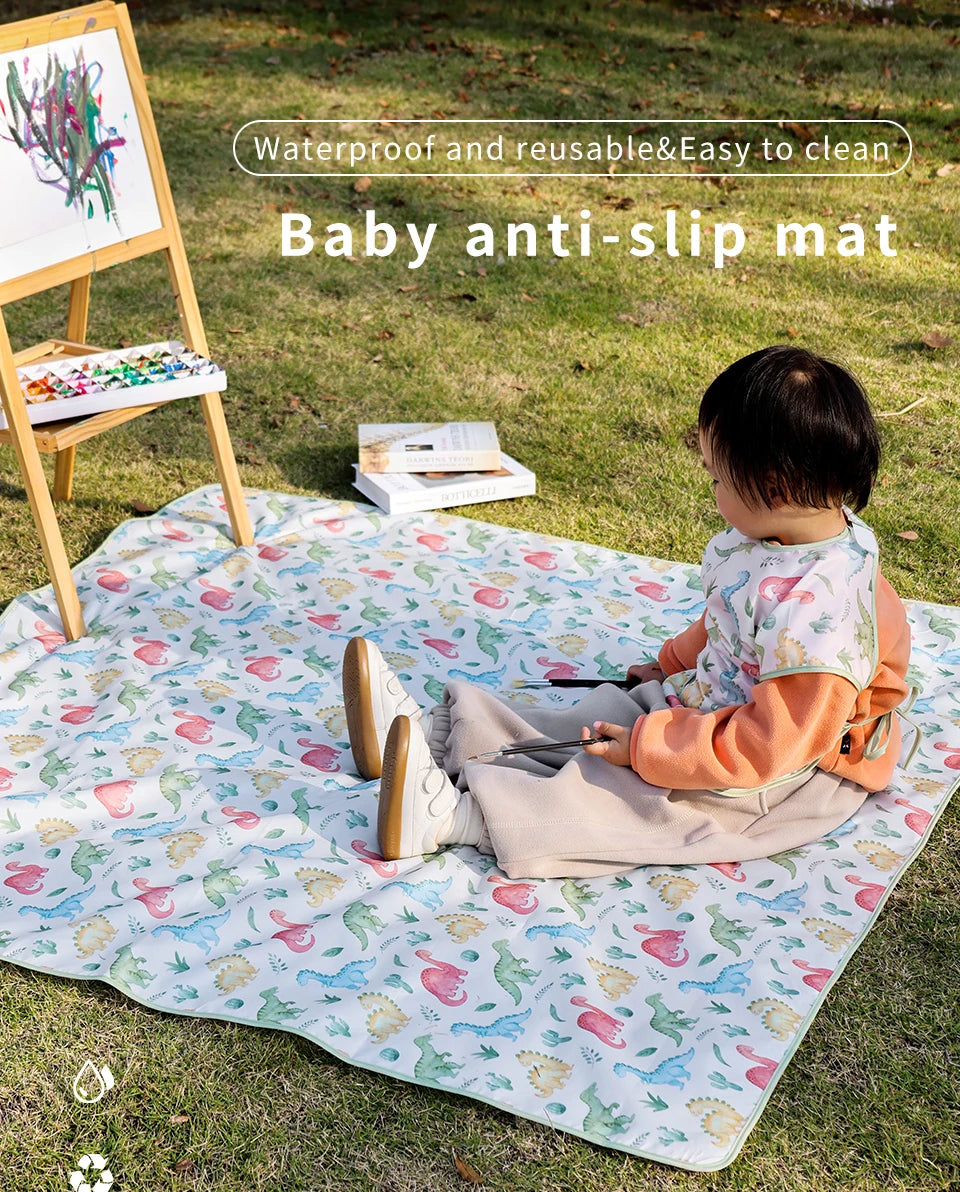 A baby is playing on a waterproof and reusable anti-slip mat outdoors on the grass.