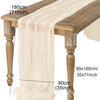 A semi-sheer beige gauze table runner draped over a wooden table, showing its length and dimensions.