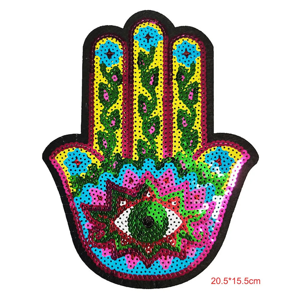 A handprint iron-on patch featuring a vibrant design with blue, green, and pink sequins.