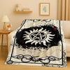 A black and white graphic flannel throw blanket featuring a sun design and decorative scrollwork.