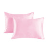A pair of pink satin pillowcases lying flat against a white background.