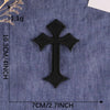 A black cross embroidery patch on a blue denim fabric background.