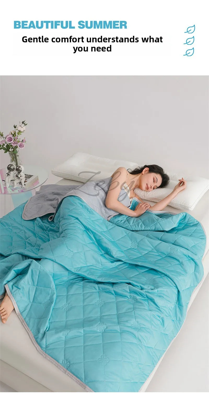 A woman is relaxing under a bright blue quilted blanket in bed, enjoying a beautiful summer night.